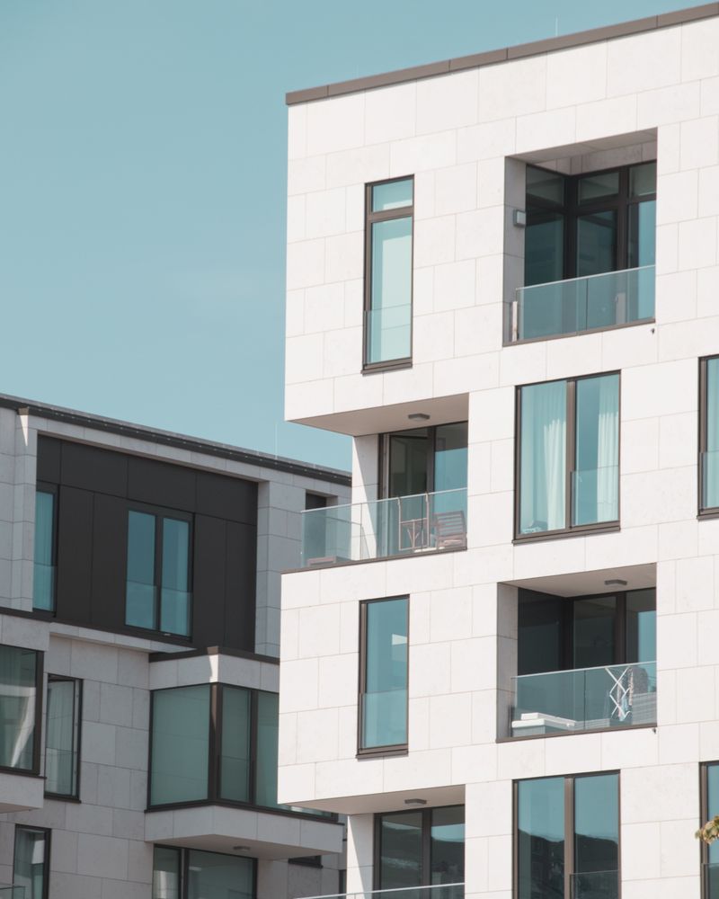 Fassade eines hellen mehrgeschossigen Wohnhauses mit Balkonen